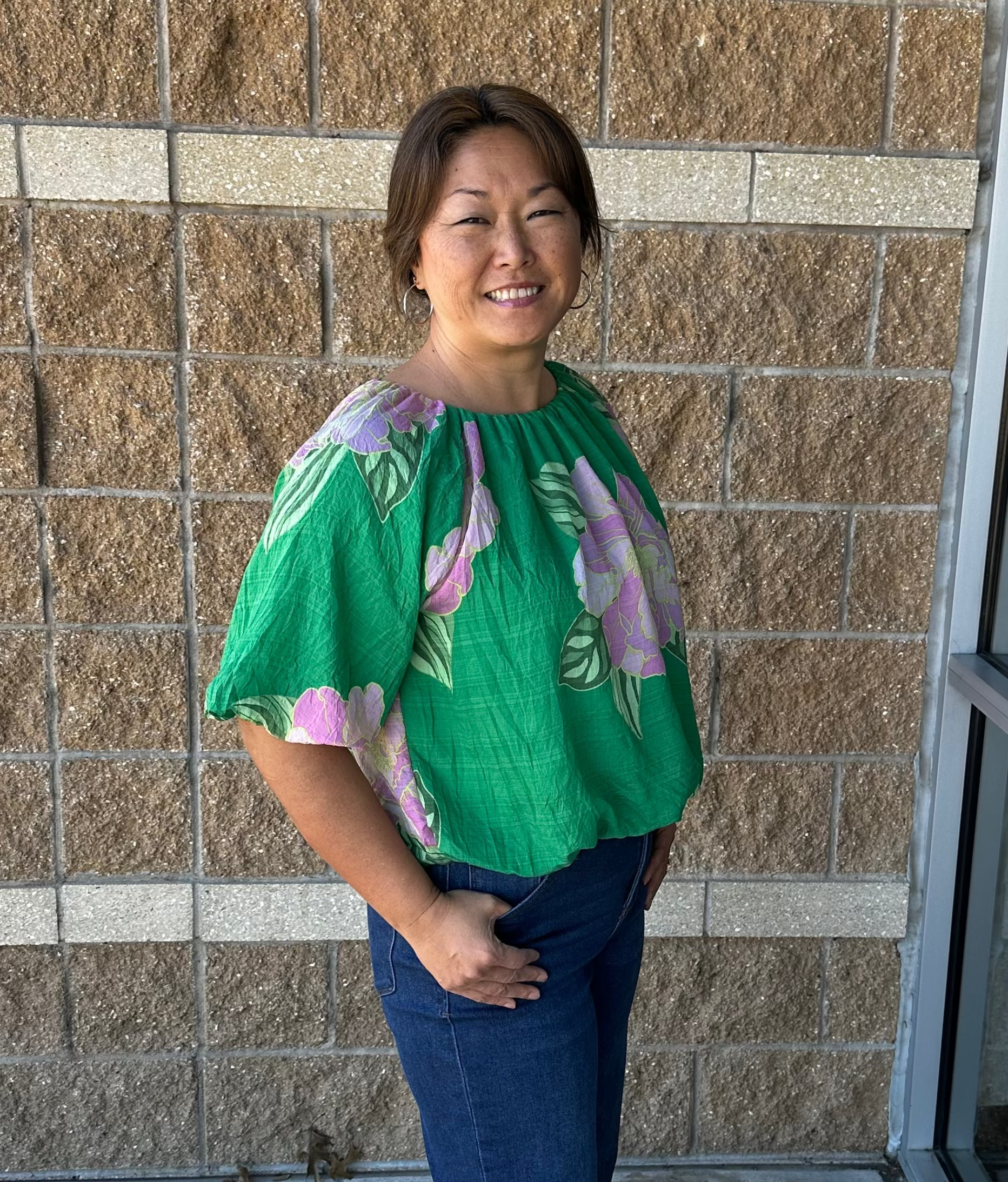 green blouse with floral print and bubble hem